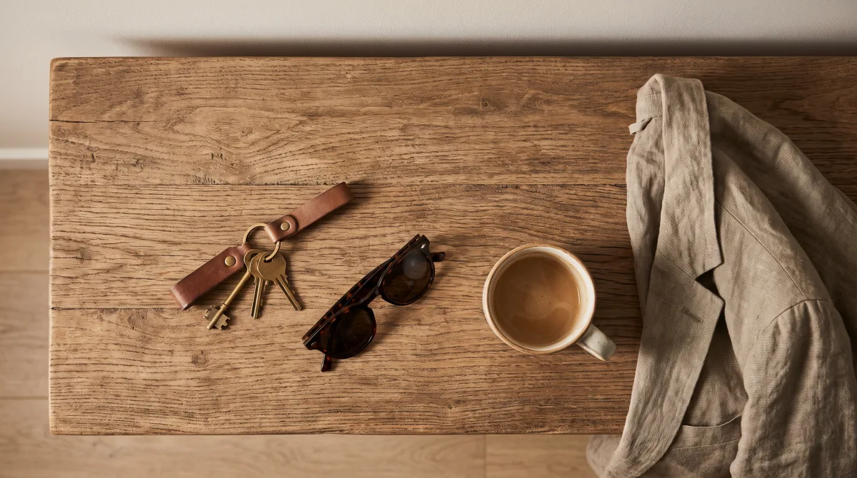 Keys and sunglasses just set down on a wood console table in a modern house entryway